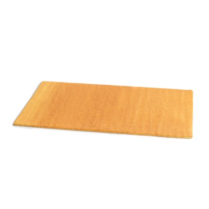 Alfombra rectangular amarilla mostaza de pelo grueso, mostrada en ángulo sobre fondo blanco.