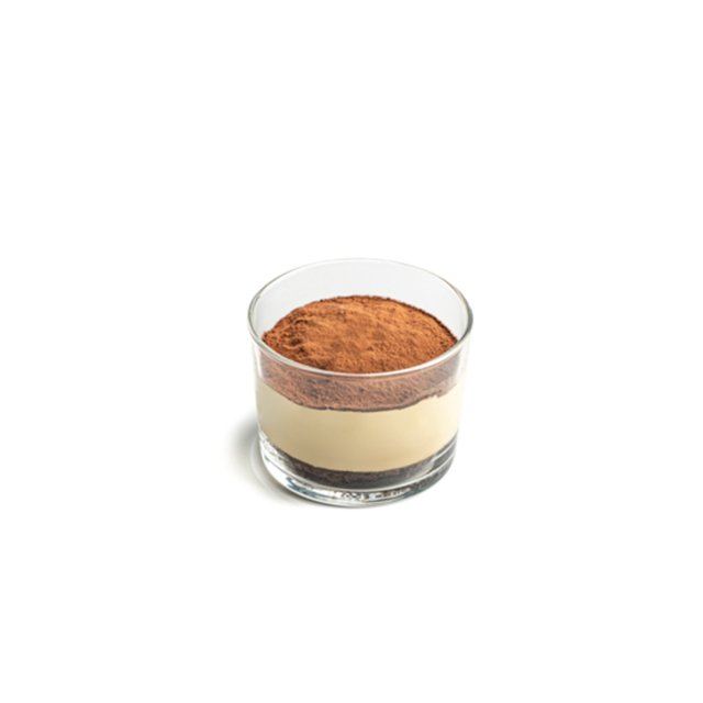 Postre de tiramisú en capas en copa de vidrio, cubierto con abundante cacao en polvo, sobre fondo blanco.